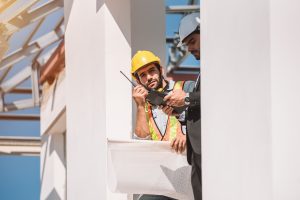 Civil engineer and construction worker manager holding digital tablet and blueprints