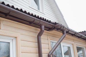 Gutter with downpipe on the roof of a house.