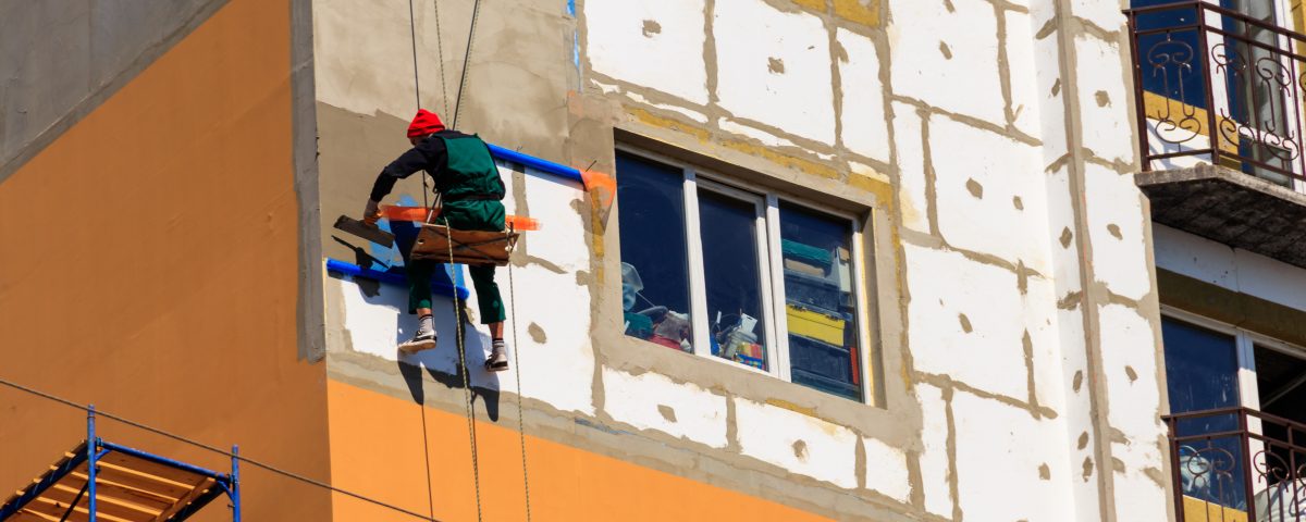 Styrofoam insulation of high-rise building. Rope access working.