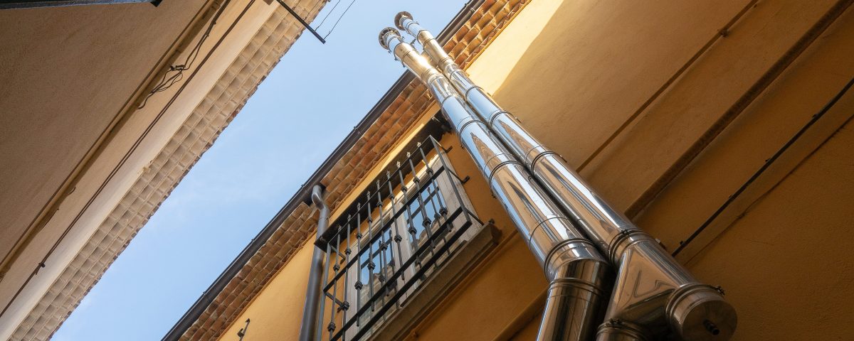 disparo-de-angulo-bajo-de-dos-tubos-mientras-suben-por-el-edificio-junto-una-ventana (1)