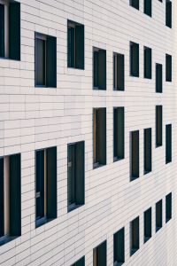 mirando-hacia-arriba-edificio-con-ventanas-asimetricas-hacia-el-cielo-fachada-arquitectura-y-la-ciudad